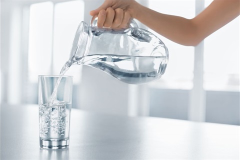 Clear water being poured into a glass.